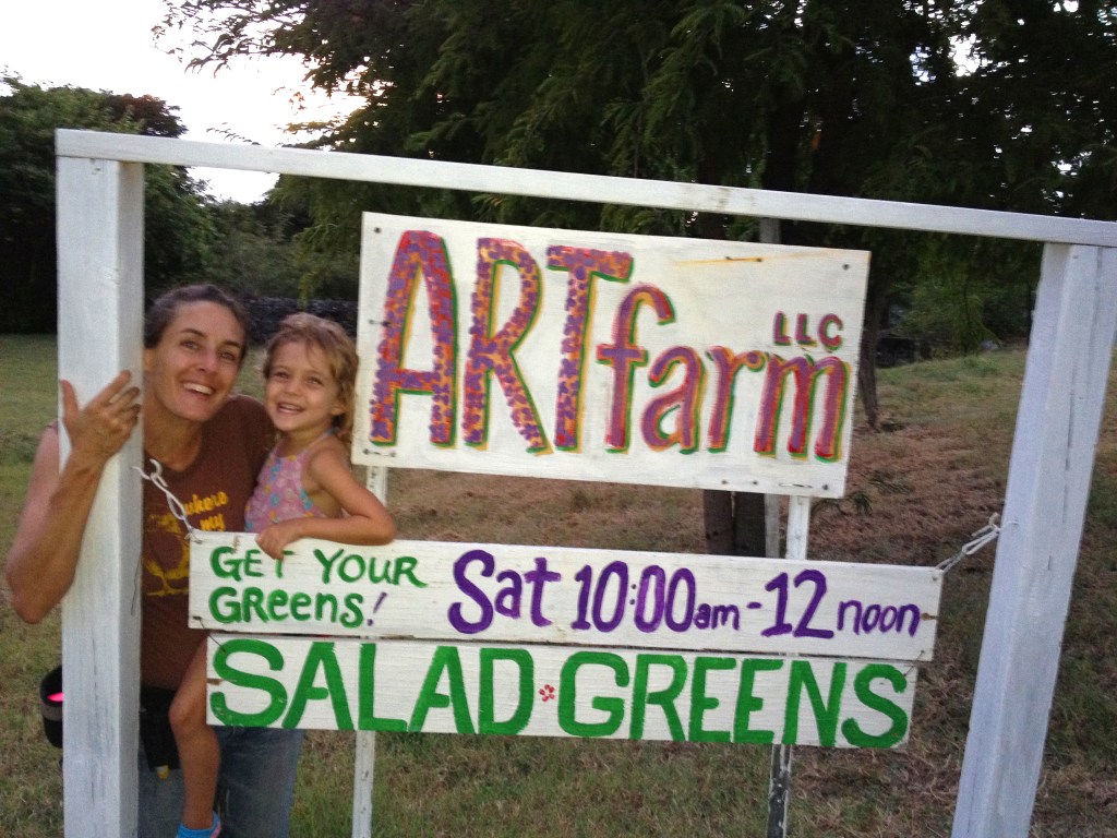 Happy ARTfarm mom and kid with the ARTfarm sign. "Get Your Greens!"