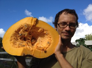 A farmer holds a half pumpkin 