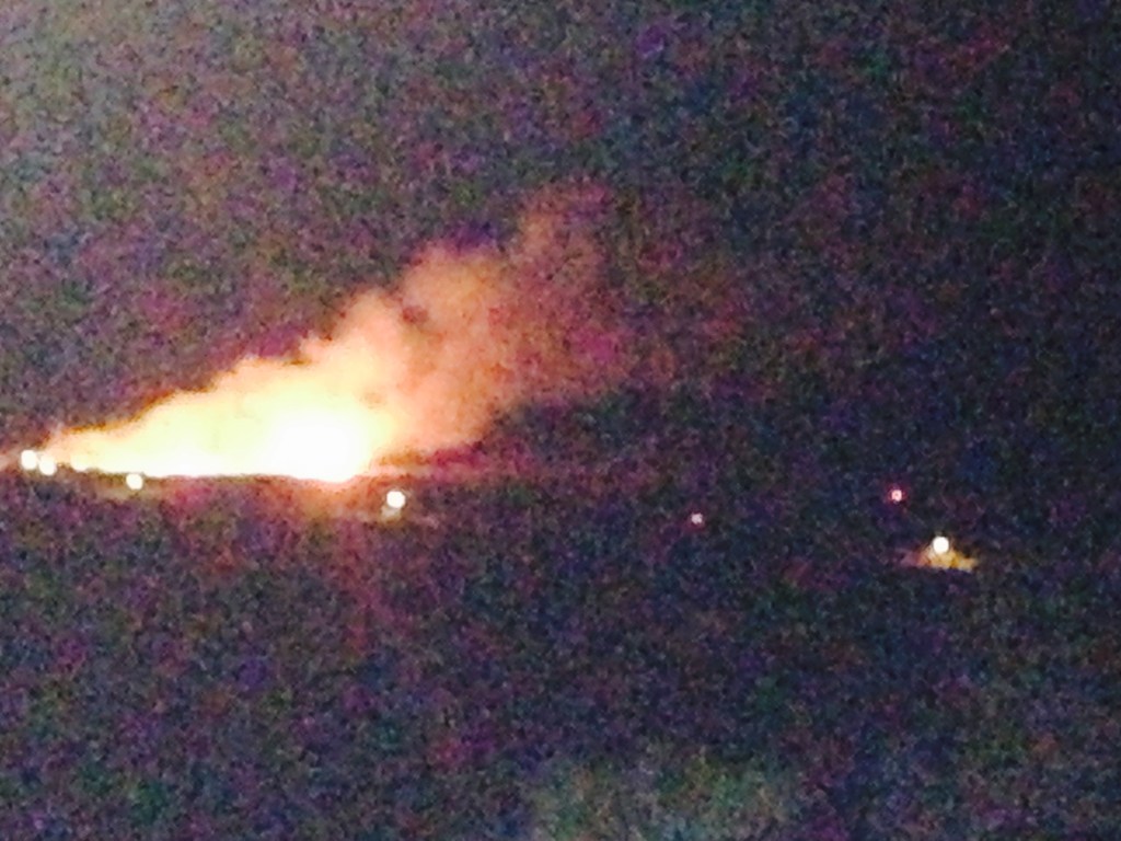 A view of the brush fire last night from the top of Spring Gut Road via a neighbor. The large yellow lights along the center of the photo below the fire are streetlights on South Shore Road. The red light on the right side is a VIFD truck. The small squarish light near the center right of the photo is us in our truck in roughly the center of ARTfarm. From our angle in the pasture it appeared that the fire was advancing rapidly toward us.